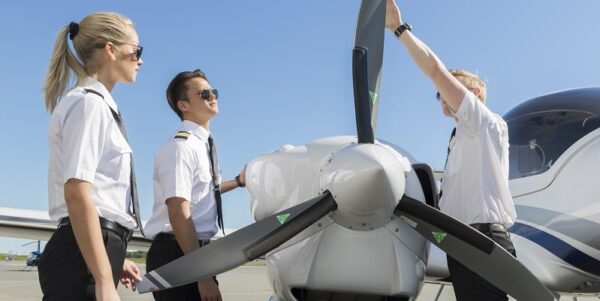 A flight instructor showing his students how to walk around an aircraft for pilot training